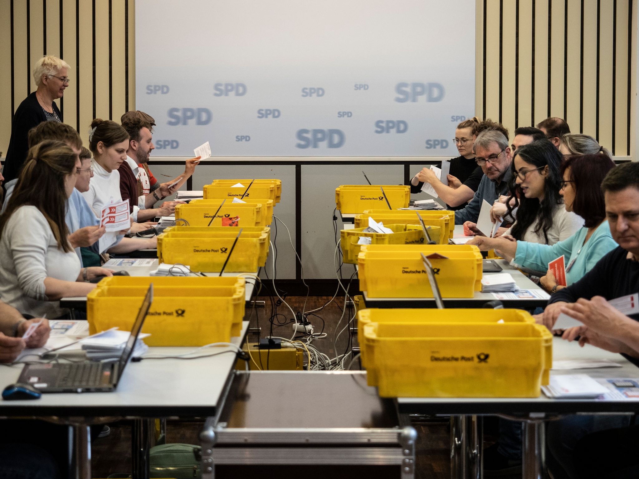 Mitglieder der SPD-Zählkommission zählen die abgegebenen Stimmen zur Mitgliederbefragung über den Koalitionsvertrag mit der CDU aus. Foto: Paul Zinken/dpa