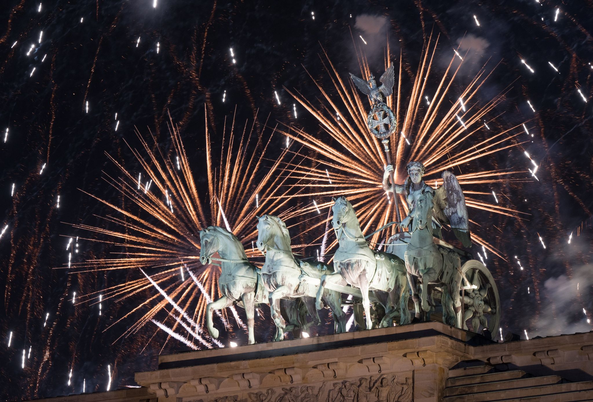 Das Feuerwerk zum Jahreswechsel steigt hinter dem Brandenburger Tor auf. Foto: Sebastian Christoph Gollnow/dpa